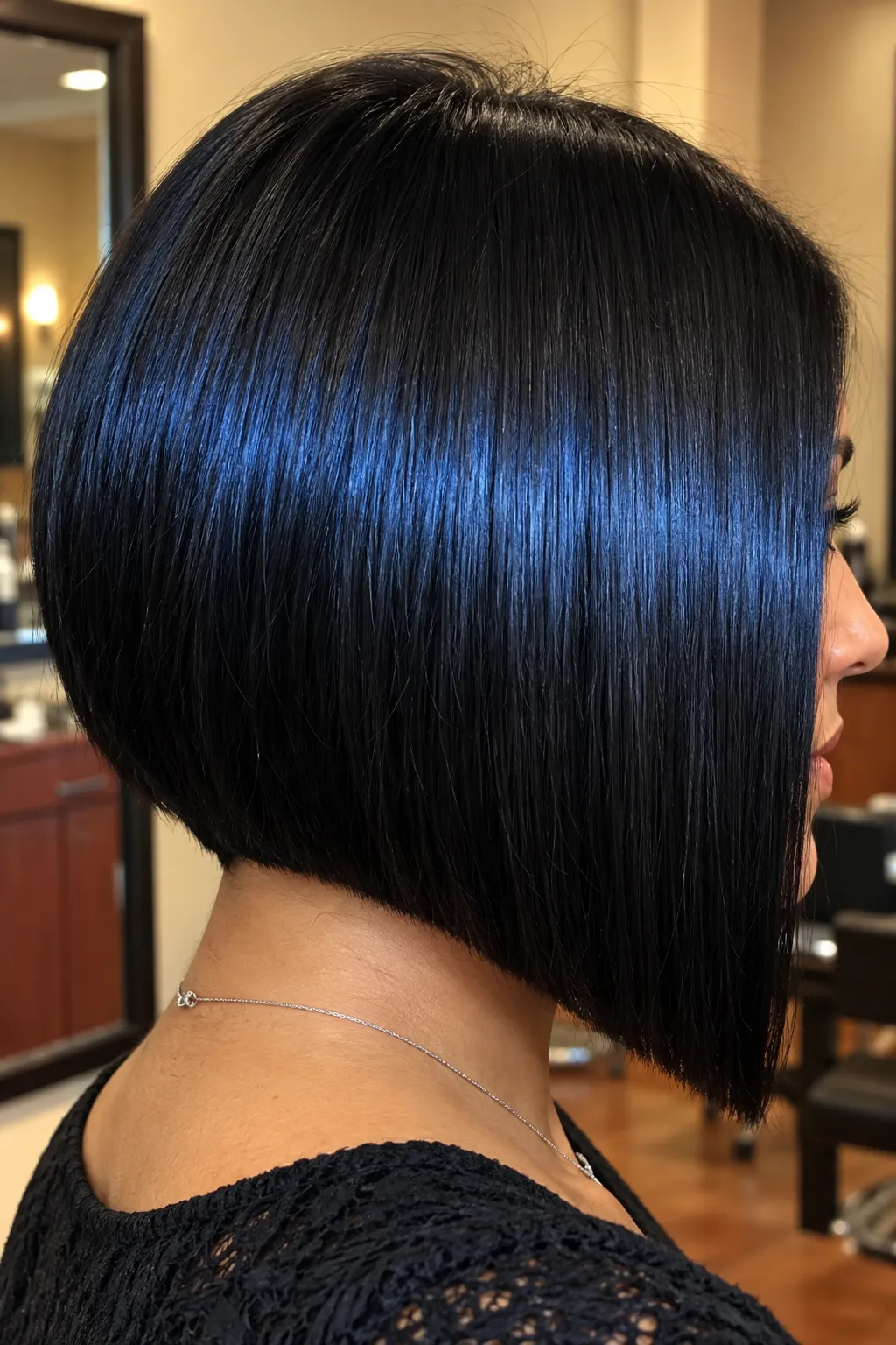 Glossy black bob shown in side profile with a sharply defined silhouette.