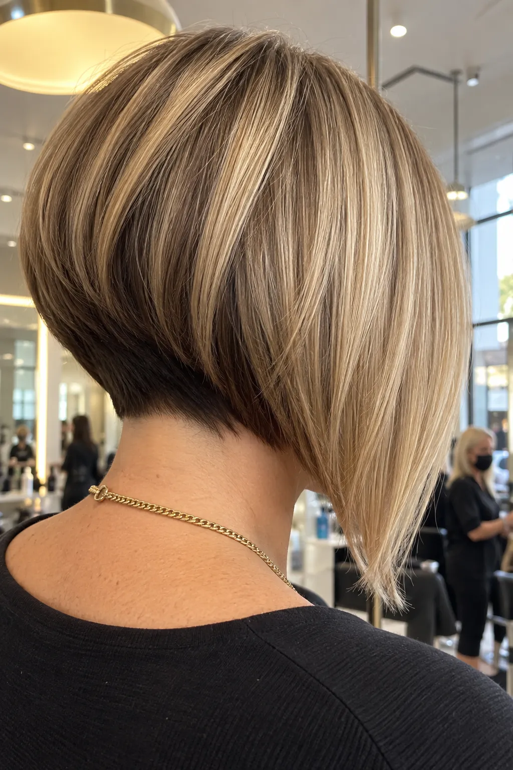 Sleek blonde inverted bob with a contrasting dark nape.